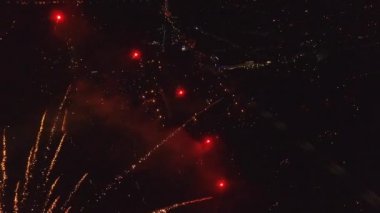 Gece gökyüzünde parlak bir havai fişek patlaması. Kara gökyüzü arkaplanlı havai fişek selamı. Yeni yıl havai fişekleri. Bağımsızlık Günü 'nü kutluyoruz. Havai fişeklerin renkli patlaması.