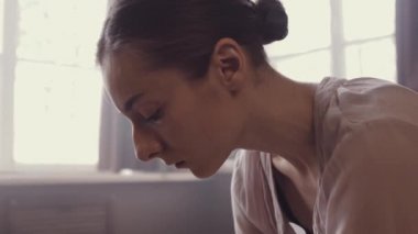 Balerin'ın yüz makyaj olmadan. Yüz doğal güzelliği. Güzel hava elbise. Dans için hazırlayın. Bir iç stüdyo panoramik pencerelere ile eski tarzda. Haze ile doğal aydınlatma.