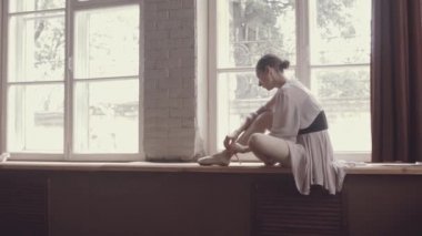 Balerin eski bir Studio büyük bir panoramik pencere pencere danstan sonra dayanmaktadır. Güzel hava elbise ile balerin.