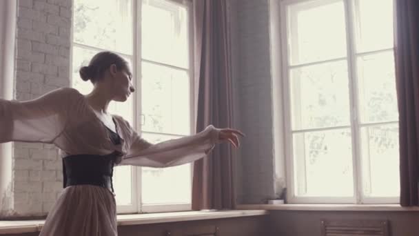 バレエ ダンス シンプルなエレガントなエレガントなドレスと大きな窓のある古いインテリア スタジオでダンスのリハーサルでバレリーナ ヘイズと自然な照明 — ストック動画
