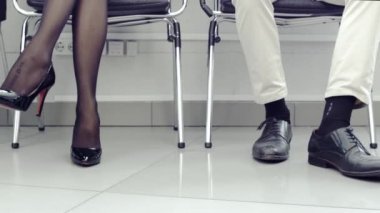 N iş görüşmesi için sıra bekliyor. Erkek ve kadın bacakları satır bir sandalyede oturan insanların Close-up.