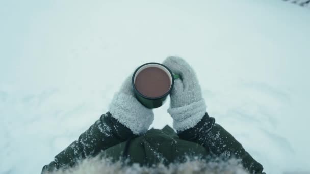 铁杯与热咖啡在女性手中针织手套在雪的背景 从正面看顶视图 — 图库视频影像
