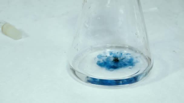 Mélanger le réactif avec de l'eau dans la fiole doseuse. Teinture du liquide en bleu avec l'expérience de laboratoire. Étude en laboratoire de l'eau. Mesures des fluides PH .