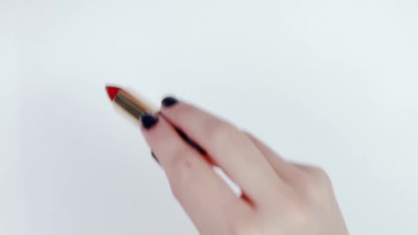 女孩在白纸背景上画一个红色的口红 一个女性手与口红的特写 黑色口红管与金尖 美丽的女性手与黑色指甲 — 图库视频影像