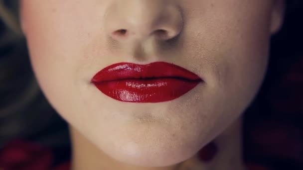 赤い口紅で女の子の唇のクローズアップ 女の子は唇を開く スローモーション スタジオの女の子の顔にプロの照明 歯を表示します フレームリップで — ストック動画
