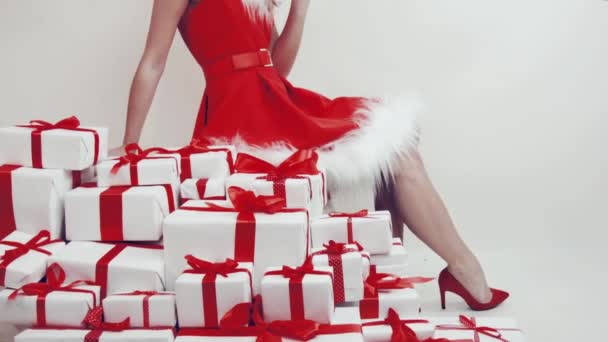 赤いリボンのついたギフトの白い箱の中には 白い毛皮を着た赤い新年のドレスの雪の乙女をイメージした美しい女の子がいます 女の子と新年の贈り物 クリスマスおめでとうございます 手土産 — ストック動画