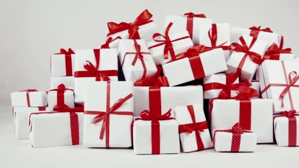 带红色缎带的白色礼品盒 并在演播室鞠躬 新年和圣诞节礼物 促销广告 黑色星期五 新年假期 许多礼品盒 白色背景的山地礼物 — 图库视频影像