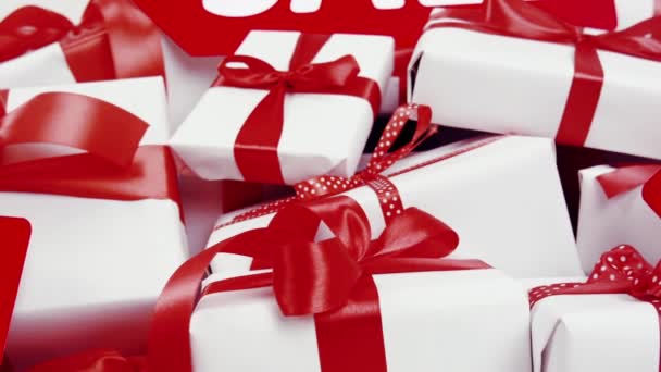 在白色的背景上有许多礼物 在红色的拱门上有 的字样 在学校里有红丝带和蝴蝶结的白色礼品盒 新年和圣诞礼物 促销广告 黑色星期五 新年假期 — 图库视频影像