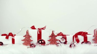 Yeni yıl oyuncakları, kırmızı toplar, küçük oyuncak Noel Baba kırmızı kurdeleli pahalı beyaz kutular, elektrik lambaları. Şöminede oyuncaklar. Bedava mesaj alanı. Noel gecesi. Video selamlaması