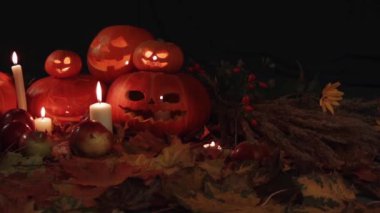 Tüm Azizler Bayramı, Şükran günü, Halloween, hasat festivali. Oyma yüzler ile turuncu kabaklar kırmızı akçaağaç sonbahar yaprakları üzerinde yatıyor, mumlar etrafında. Kompozisyon kabaklar, mumlar, yaprakları, elma, vahşi gül