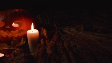 Tüm Azizler Bayramı, Şükran günü, Halloween, hasat festivali. Sonbahar akçaağaç yaprakları yalan korkunç yüz oyulmuş üç büyük kabak. Büyük küçük mumlar etrafında vardır. Kabak içinde mum yanık.