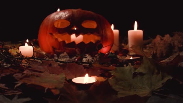 所有圣徒节 感恩节 万圣节 收获节 一个大南瓜 雕刻可怕的脸 它在秋天的枫叶里 大蜡烛在周围 南瓜内的蜡烛燃烧 — 图库视频影像