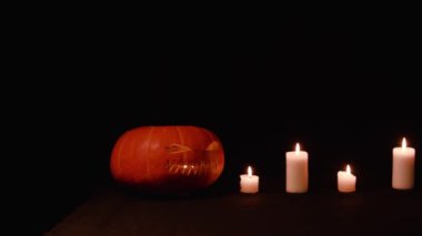 Tüm Azizler Bayramı, Şükran günü, Halloween, hasat festivali. Mumlar bir satırda stand, sol bir kabak olduğunu. Arka siyah arka plan. Çekim için uzun menzilli plan.
