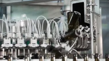 Bir bira fabrikasında otomatik dolum makinesi. Konveyör bandı üzerinde bira için cam şişeler. Sanayi için dolum makinesi.