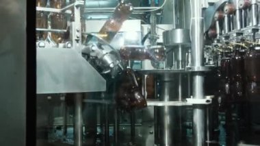 Bir bira fabrikasında otomatik dolum makinesi. Konveyör bandında bira için plastik şişeler. Sanayi için dolum makinesi.