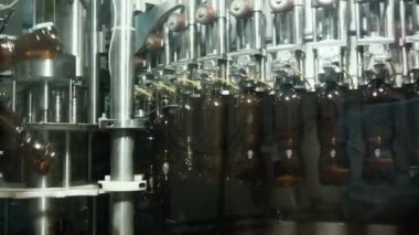 Bir bira fabrikasında otomatik dolum makinesi. Konveyör bandında bira için plastik şişeler. Sanayi için dolum makinesi.