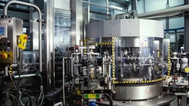 Bir bira fabrikasında otomatik dolum makinesi. Konveyör bandı üzerinde bira için cam şişeler. Sanayi için dolum makinesi.