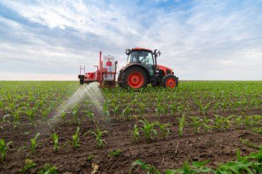 Tractor spray fertilize field with insecticide herbicide chemicals in agriculture field  clipart