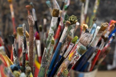 Kovada bir sürü kirli boya fırçası var. Farklı sanatçı fırçaları, yakın çekim görüntüsü