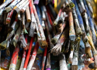 Kovada bir sürü kirli boya fırçası var. Farklı sanatçı fırçaları, yakın çekim görüntüsü