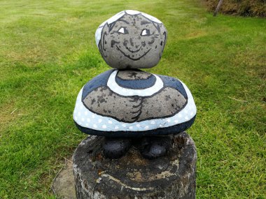 Yerleştirilir ve bir kadın şeklinde boyalı taşlar