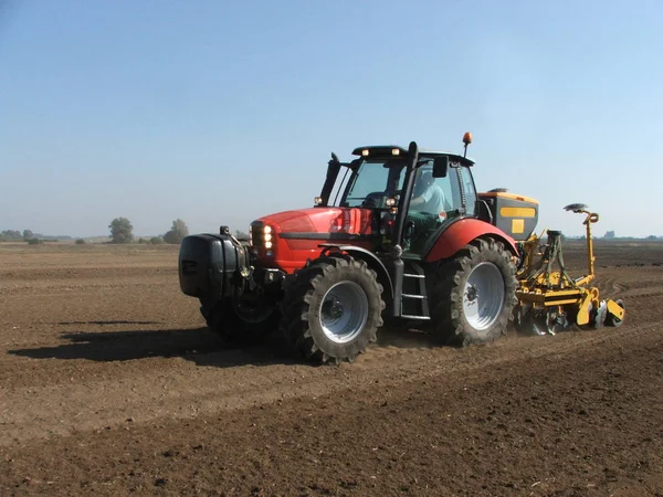 Burgonyaültetvényes vörös traktor — Stock Fotó