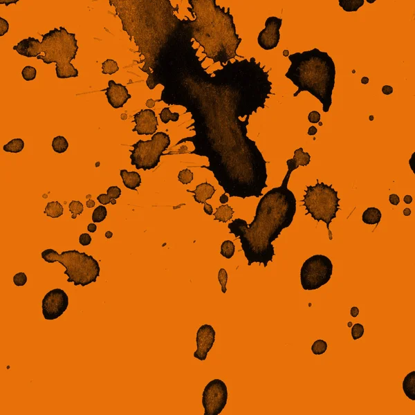 abstract black paint splatters texture on orange background