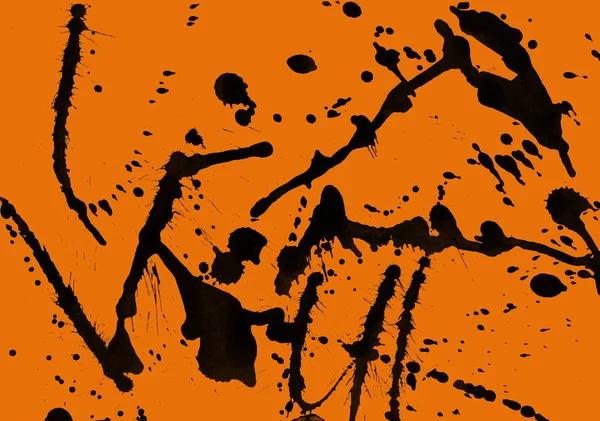 abstract black paint splatters texture on orange background