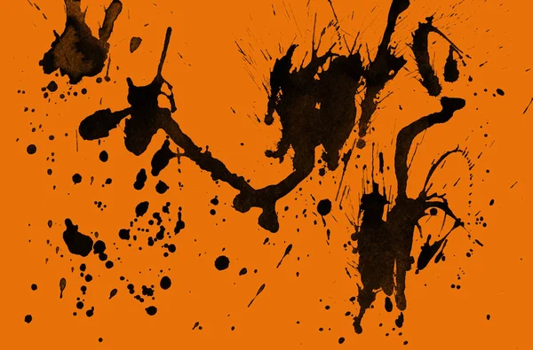 abstract black paint splatters texture on orange background