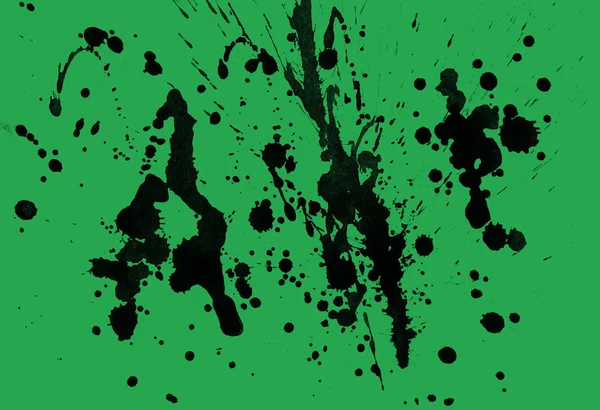 abstract black paint splatters texture on green background