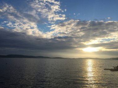 Adriyatik Denizi kıyısında. Günbatımı bulutlar ile.