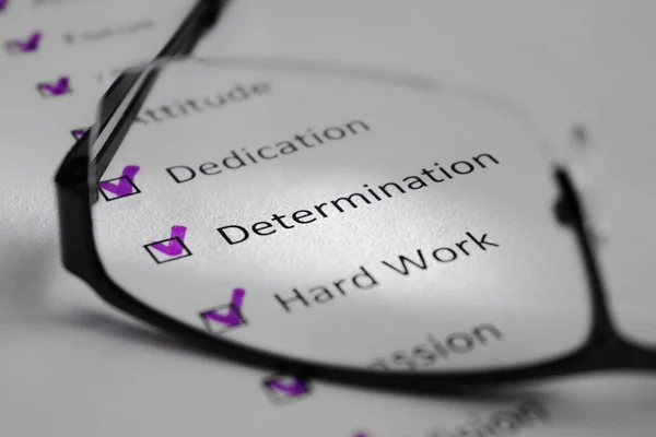 Beyaz bir levha üzerinde belirlenmesi yazıt. Bu bir motivasyon kontrol listesi ile başarı için puan var. Satırları siyah kareler onay işaretleri vardır. Resmi gözlük lens ile çekilen ve bir ışık huzmesi tarafından vurgulanan.