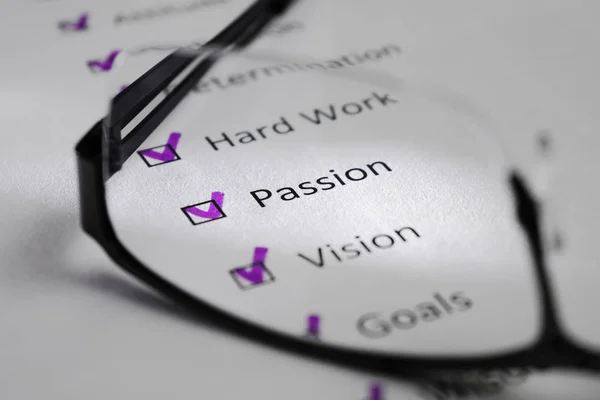 Beyaz bir levha üzerinde tutku yazıt. Bu bir motivasyon kontrol listesi ile başarı için puan var. Satırları siyah kareler onay işaretleri vardır. Resmi gözlük lens ile çekilen ve bir ışık huzmesi tarafından vurgulanan.