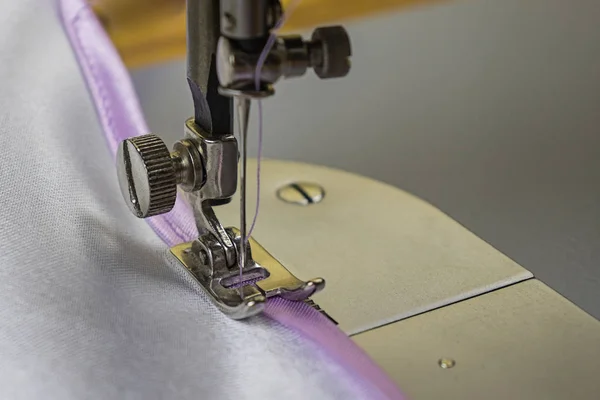 Dikiş makinesi beyaz kumaş ve pembe kurdele, detay.