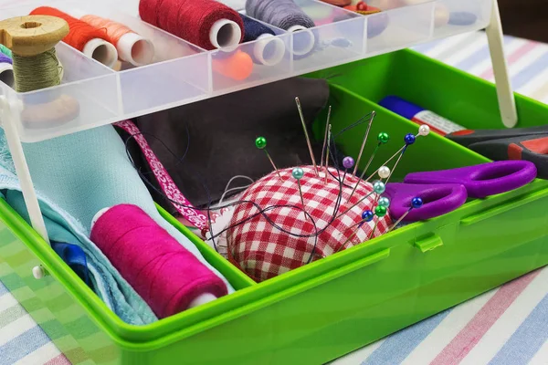 Plastik kutu dikiş aksesuarları ile. Pim, makas, kumaş, iplik biriktiricileri