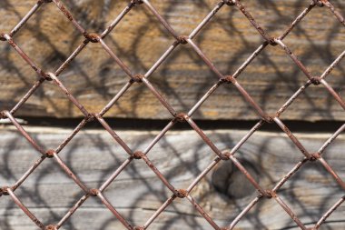 Eski paslı metal örgü, altında dikey ahşap plakalar