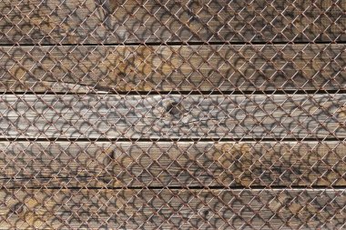 Eski paslı metal örgü, altında dikey ahşap plakalar