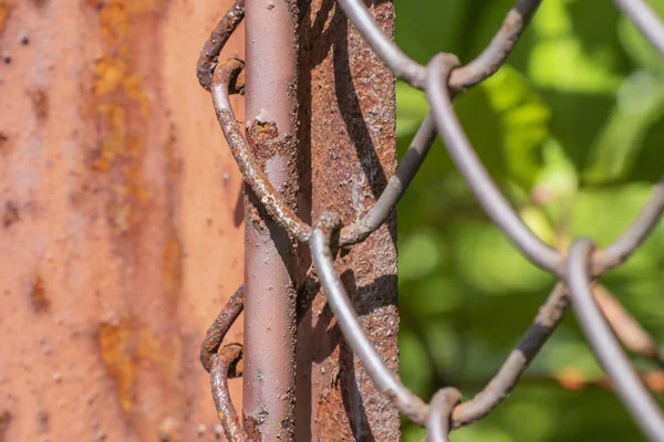 Rader av trådnät och Rostig metall pelare av staket. Rutnätsstruktur för trådnät. Grunge bakgrund. Rustika mönstrade texturer. — Stockfoto