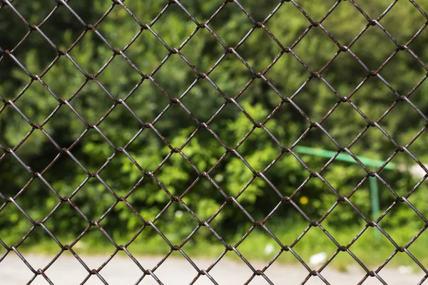 Rows of wire mesh and rusty metal pillar of fence. Wire mesh grid texture. Grunge backdrop. Rustic patterned textures. — Stock Photo, Image