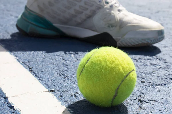 Tenis topu ve beyaz spor ayakkabı