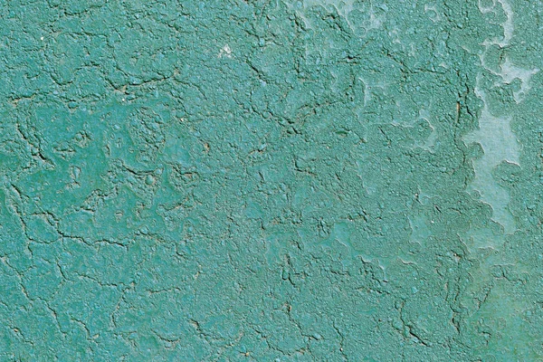 Concrete background in cracks of green color