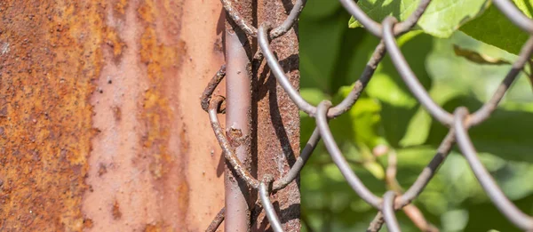 フェンスの金網と錆びた金属柱の列。ワイヤ メッシュ グリッド テクスチャ。グランジの背景。素朴なパターンテクスチャ. — ストック写真