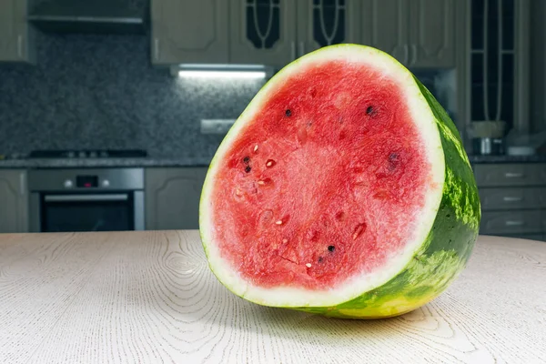 Mutfak masasında duran yarım olgun karpuz. Mutfak arka planda