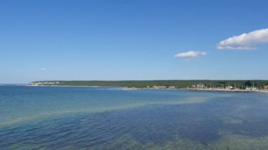 Köy, Lickershamn, Gotland Adası, İsveç'te yaz aylarında. Baltık Denizi kıyısında, su mavi ve tekne palamarla. Açık gökyüzü.