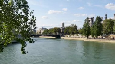 Paris, Fransa, yaz. Saint-Louis Adası sermaye, Saint-Jacques kuleye, Şehir Tiyatrosu ve Seine Nehri üzerinde Belediye Binası bir görünümü yoktur. İnsanlar bir köprüden geçiyor.