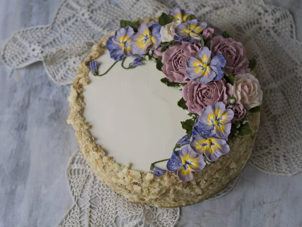 Bolo de Napoleão com nata de baunilha, decorado com flores de creme de manteiga - rosas e persas. Estilo vintage. Fundo cinzento, guardanapo de renda. Espaço de cópia, close up — Fotografia de Stock