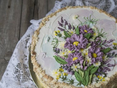 Napolyon pasta vanilya krema ile buttercream çiçek - yaz kır çiçekleri ile süslenmiş. Vintage tarzı. Ahşap arka plan, dantel peçete. Uzay kopyalayın, yakın çekim