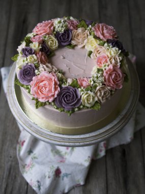 Pembe kremalı pasta buttercream çiçekler - peonies, gül, karanfil - eski ahşap arka plan ile dekore edilmiştir. Vintage tarzı. Yakın çekim, uzay, seçici odak Kopyala