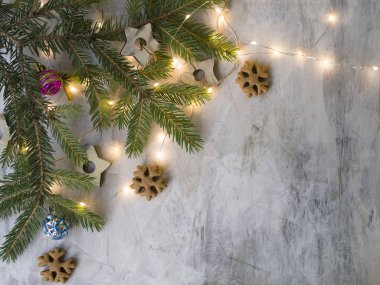 Noel kartı ile şube Noel ağacı, ahşap yıldız, eski vintage tahtası, kar taneleri, renkli toplar ve parlayan ışıklar zencefilli kurabiye gibi. Yeni yıl arka plan. Metin, üstten görünüm, düz için yer yatıyordu