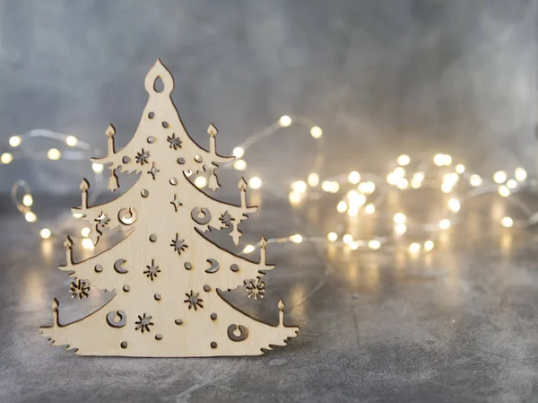 Stylish Christmas handmade tree made of wood on gray background with glowing lights. Overhead of Christmas New Year holiday background. Selective focus, place for text — Stock Photo, Image